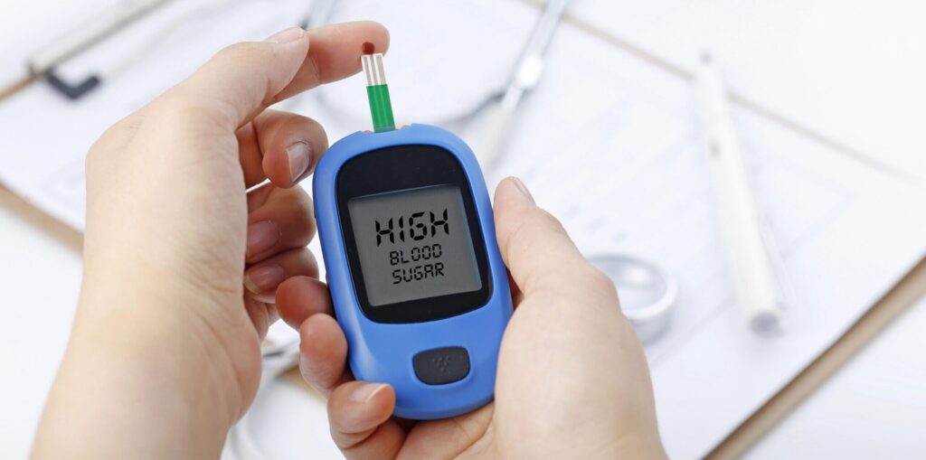 handing holding a blood glucose monitor