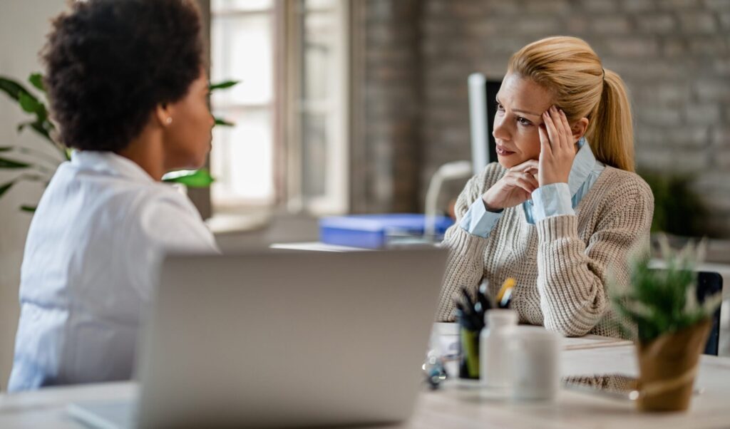 women at desk looking stressed